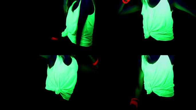 女人用UV面漆，发光的衣服，发光的手镯在镜头前跳舞，身体拍摄。高加索女人。。