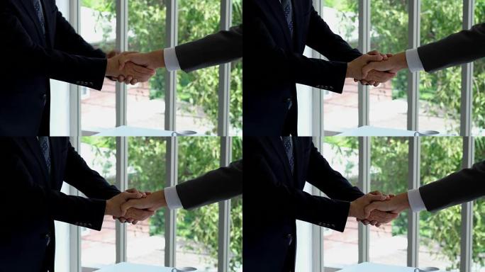 两个亚洲商人合作伙伴在办公室背景，业务概念，盈利协议，合作方面握手