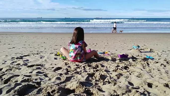 无法识别的女孩在海滩上玩玩具