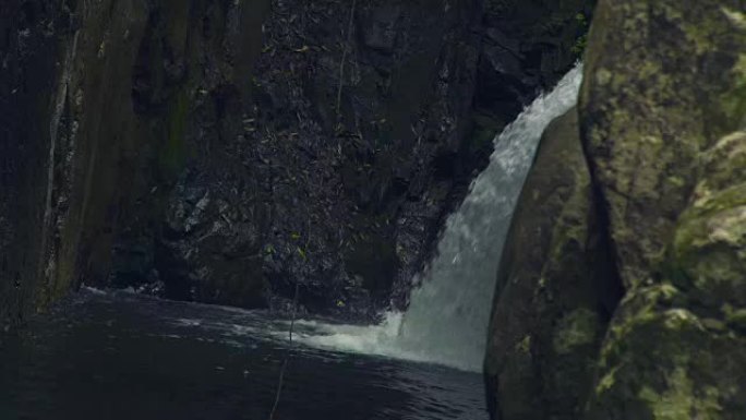 从山上的瀑布流出的河水在河里的大石头上流动。瀑布梯级中的流山河