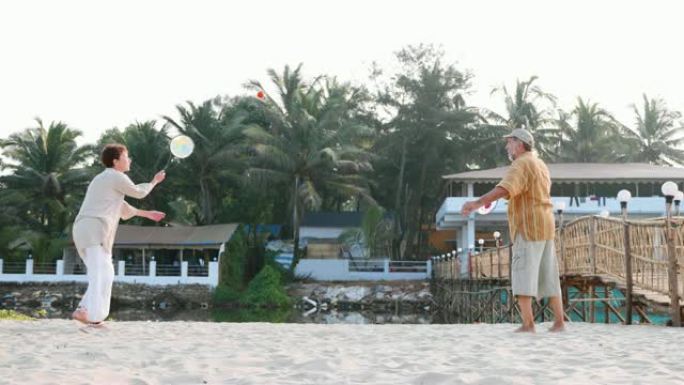 活跃的高级夫妇在海滩上慢动作打太极拳。