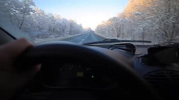 男子在冬季道路上缓慢驾驶汽车。在冬天，大多数驾车者仍然放慢脚步，要小心。