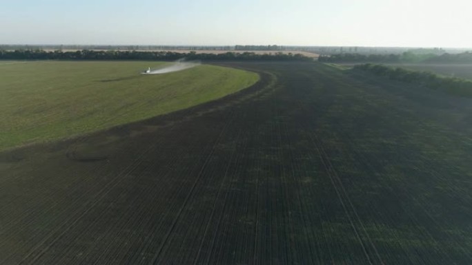 农业，双翼飞机用小麦飞过田野，并在老式推进飞机的鸟瞰图中飞溅化学物质以防止害虫