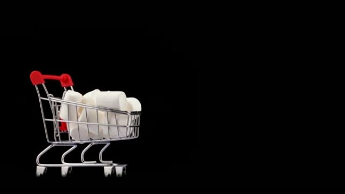 超市手推车半框白色棉花糖堆。旋转。孤立在黑色背景上。特写。宏观。