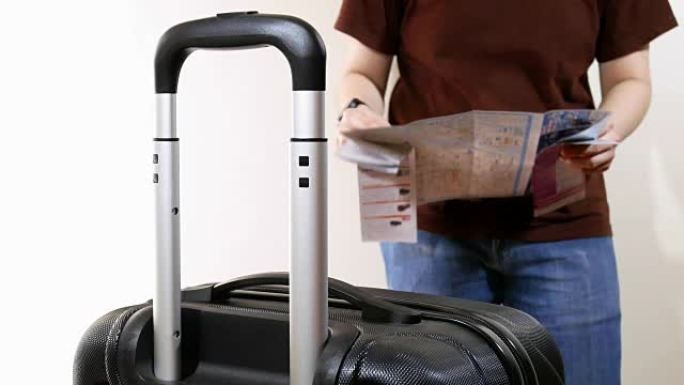 带着旅行行李的男人用纸质地图计划去一个以白色为背景的地方旅行