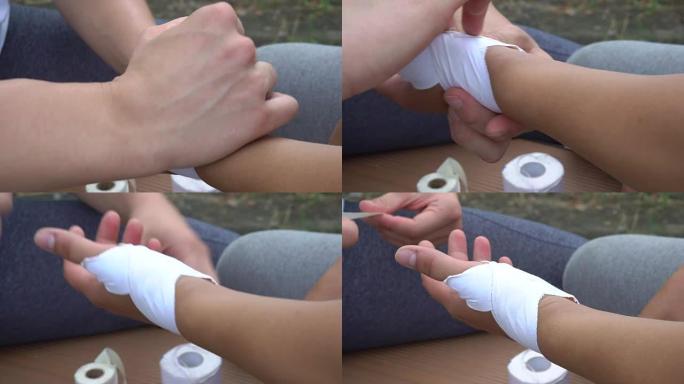 一个人用白色石膏覆盖另一只手的一部分。受伤了。人类完成了覆盖的手，并开始使用石膏的另一部分