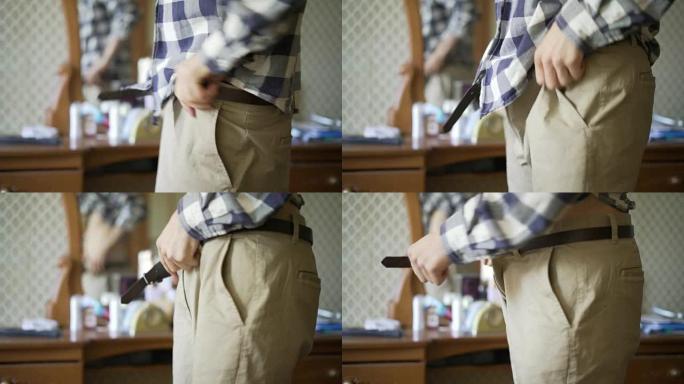 男人的手穿上休闲裤或短裤和紧身带特写