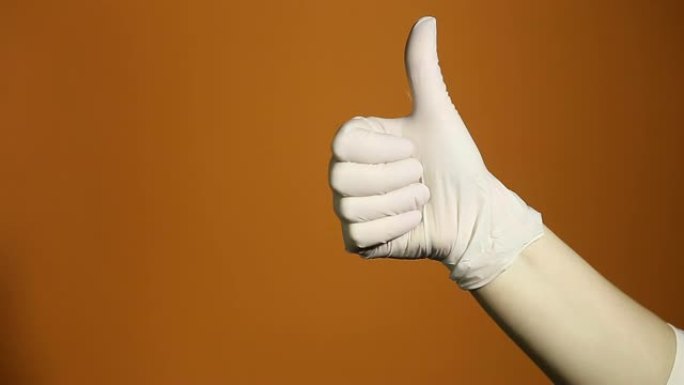 双手的概念的手势显示拇指向上，因为获胜者的庆祝和祝贺孤立在橙色背景上