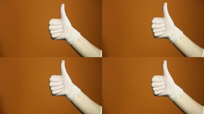 双手的概念的手势显示拇指向上，因为获胜者的庆祝和祝贺孤立在橙色背景上