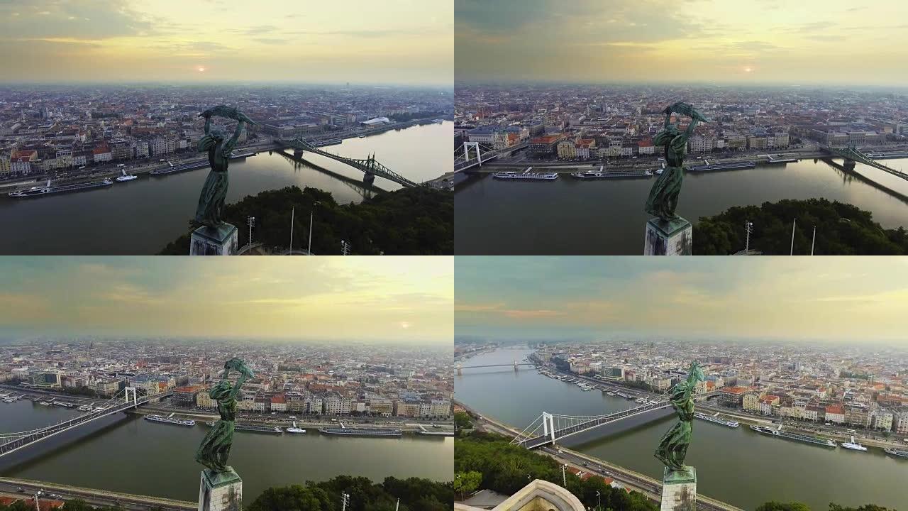在自由女神像周围飞行，背景是布达佩斯的天际线。匈牙利布达佩斯——日出时的4K航拍画面