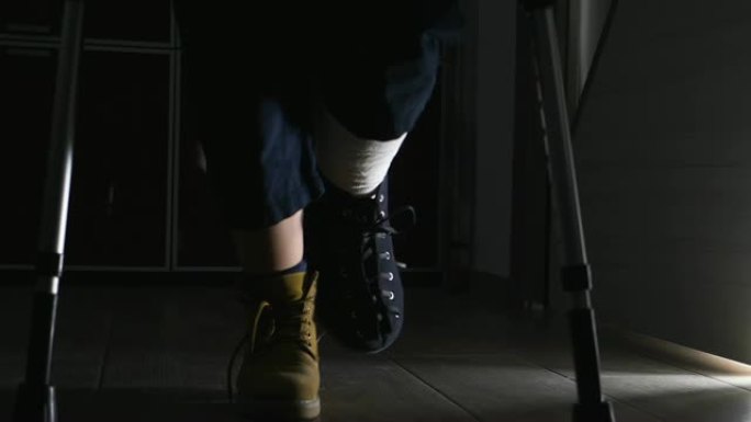 腿部骨折，残疾，残疾-受伤的男子用拐杖wlaking着-室内