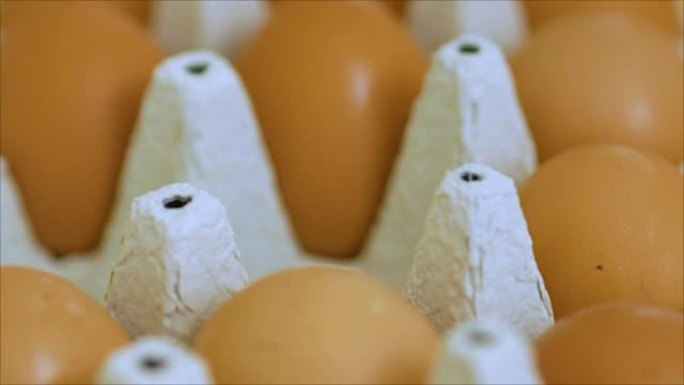 用手折叠包装中的鸡蛋。关闭灰色鸡蛋纸箱，人们将鸡蛋从纸箱中取出。