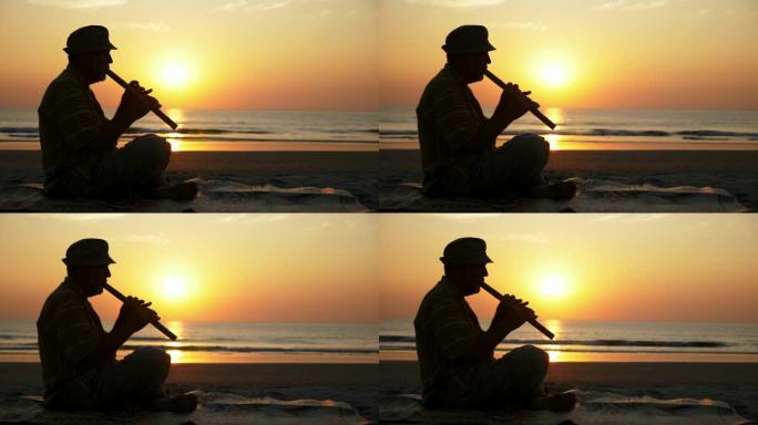 日落时在沙滩上演奏竹笛的老人剪影