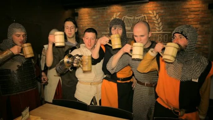 中世纪的骑士在黑暗的背景下喝啤酒