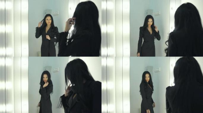 漂亮女孩在镜子旁边量一件衣服。
