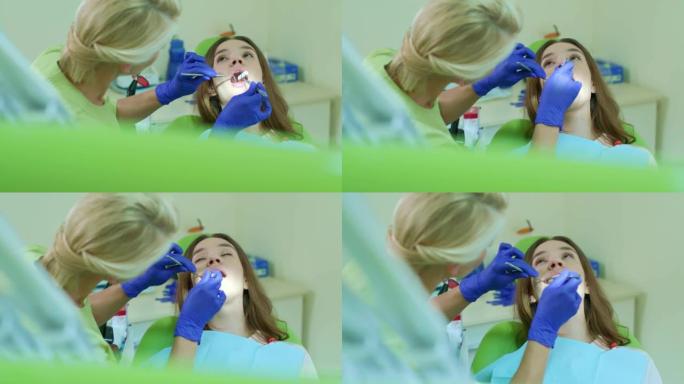 牙医把棉塞放进病人的嘴里。牙科治疗过程