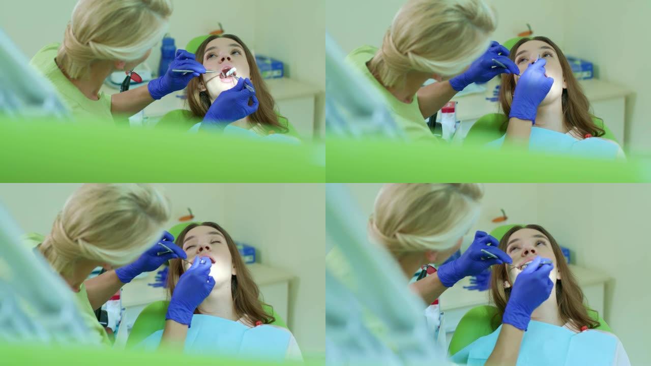 牙医把棉塞放进病人的嘴里。牙科治疗过程