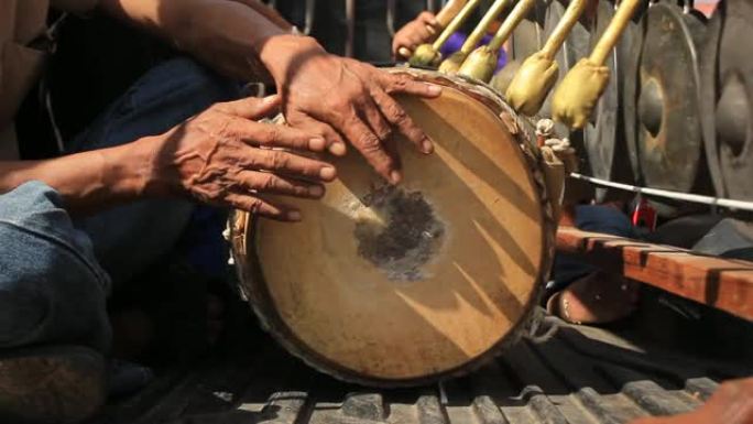 泰国男子乐队演奏传统的打击乐器，包括锣和长长的山羊皮鼓，同时游行前往Shan/Thai Yai佛教寺