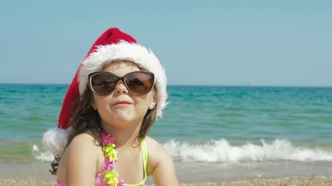 海滩上戴着圣诞老人帽子的快乐孩子。