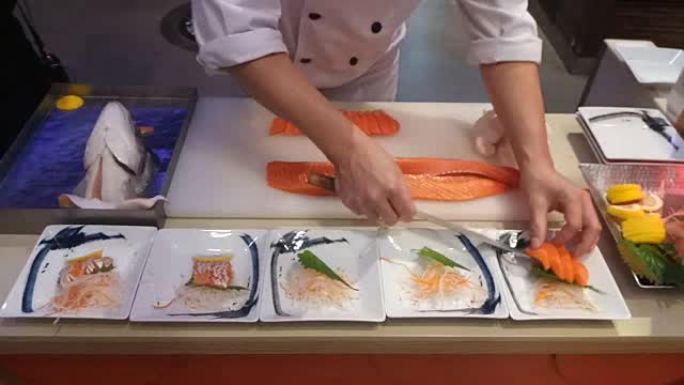 厨师将鲑鱼切成薄片，以便在厨房烹饪
