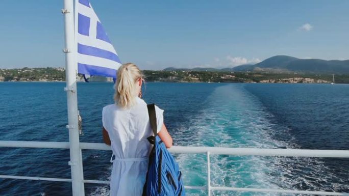 在希腊的游轮度假。年轻女子乘坐海上游轮离开希腊岛。浪漫的海上旅行，看着美丽的海岸。慢动作高清