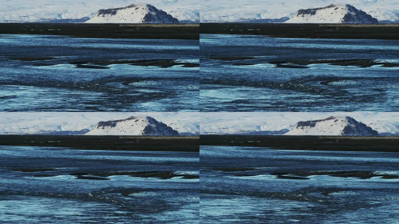 背景为白雪皑皑山脉的黑沙滩拍摄