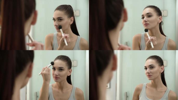 面部化妆。女人用粉末照镜子