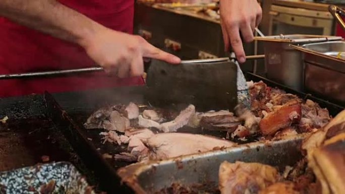 屠夫用大刀割肉。在食品市场上，人手切片和切肉分类的特写镜头