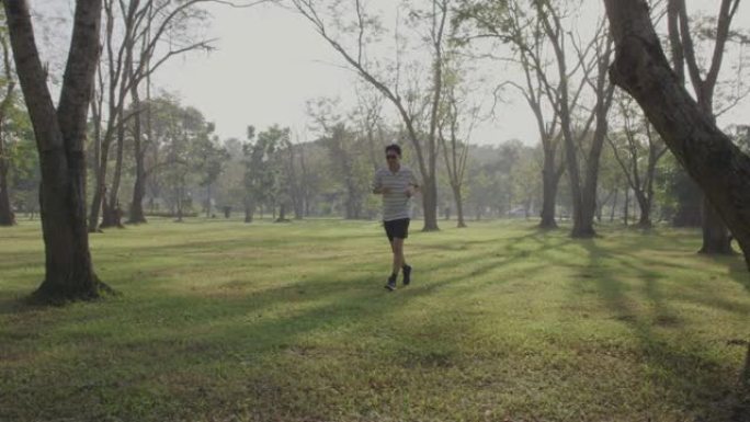 戴着墨镜的男人在公园里奔跑，4k