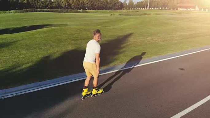 老人在日出背景上的公园里溜冰