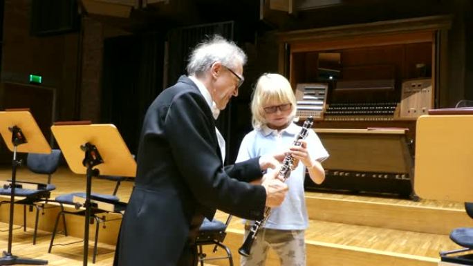 男音乐家教可爱的男孩如何演奏双簧管。