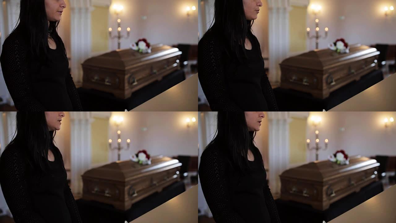 悲伤的女人和棺材在教堂的葬礼上