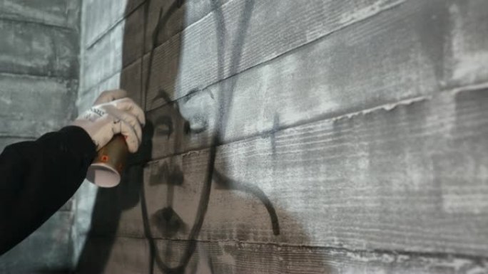 涂鸦艺术家用气雾罐在墙上制作轮廓涂鸦线