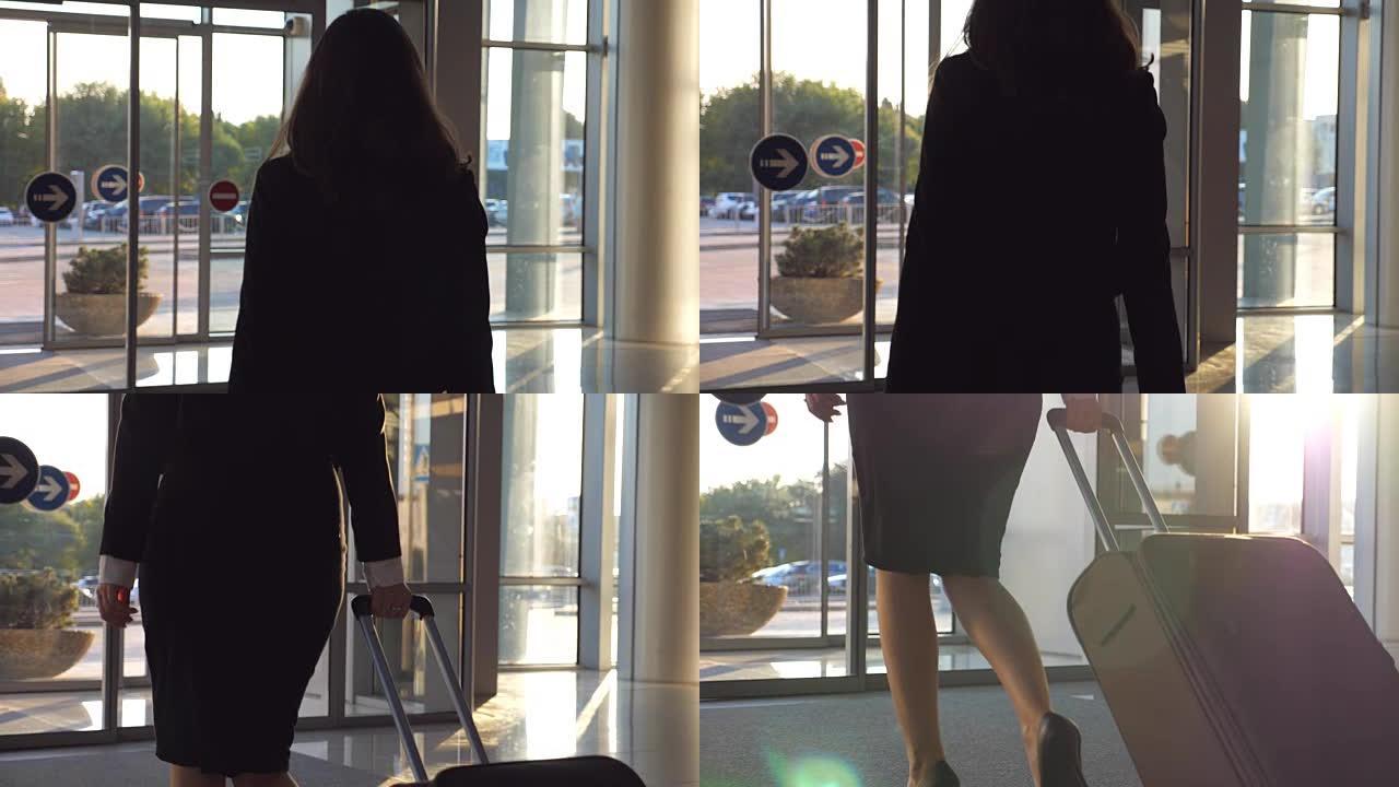 穿着高跟鞋的年轻女子带着手提箱沿着机场大厅或候机室行走。跟着商务小姐带着行李从航站楼出来。旅行或度假