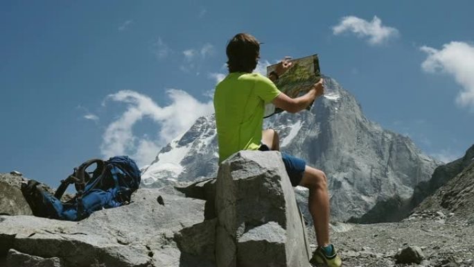 游客徒步旅行者研究地图并在山上探索路线，坐在岩石上，慢动作