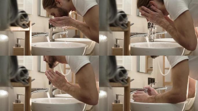 早晨卫生。男子在浴室用清水洗脸