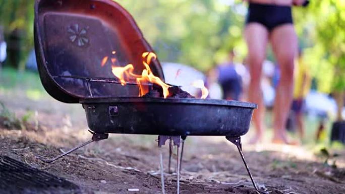 夏季周末烧烤。烤架着火了。烧烤架上发光的木炭和火焰。食物、人和假期概念。4K (UHD