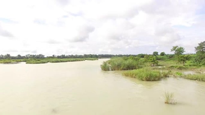 巨大安静的浑浊河水在小农业社区村庄流动。无人机天线