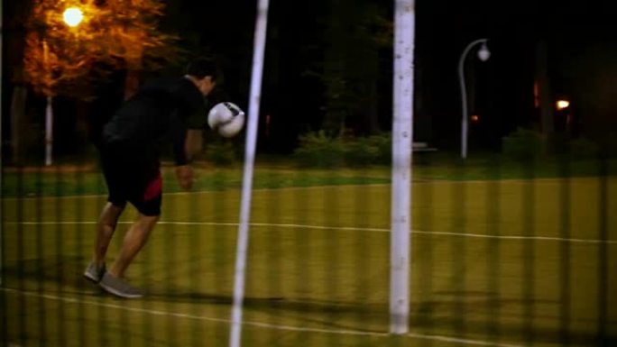 年轻的足球运动员踢球，球飞向守门员，守门员接球
