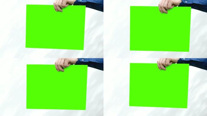 人的手举起和放下绿色的屏幕。循环视频