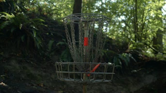森林高尔夫球篮中的橙色飞盘慢动作