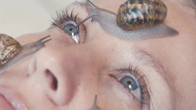 雌性脸上蜗牛的特写。蜗牛粘液使皮肤恢复活力