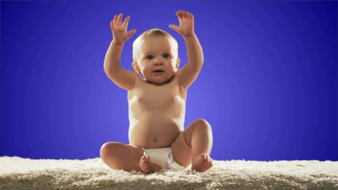 可爱的婴儿坐在地毯上挥舞着手臂。宽镜头