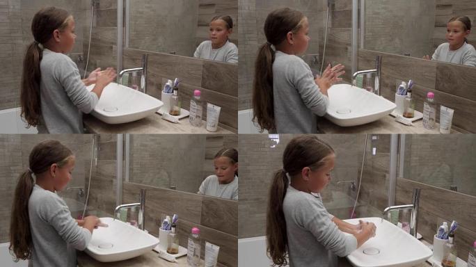 可爱的小女孩在浴室用肥皂洗手