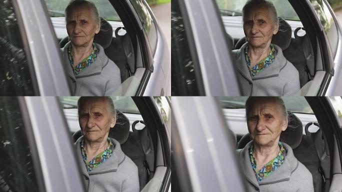 一个开着的车窗里有皱纹的老妇人的肖像。