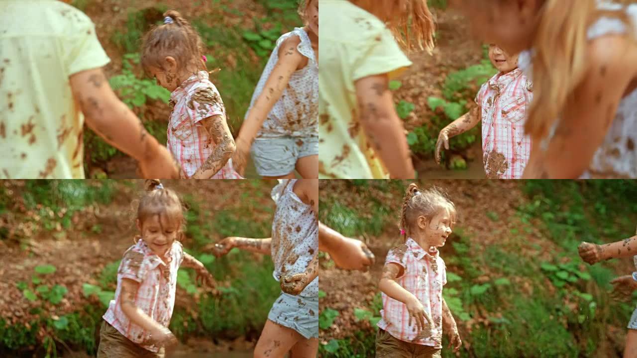 SLO MO三个女孩在森林小溪里玩泥
