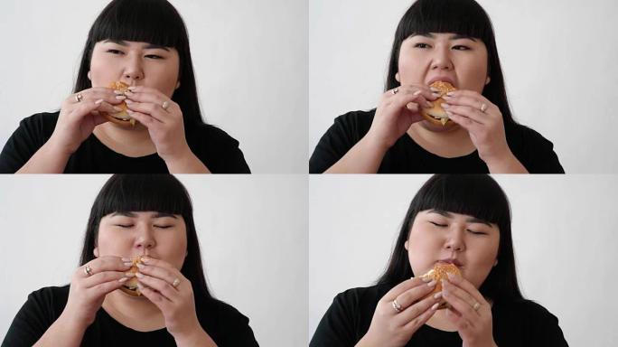 亚洲外表的女孩吃汉堡，享受味道。不是年轻人的健康饮食