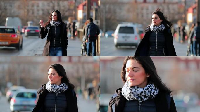 女人在寒冷的冬季日落时以4K 60fps慢动作走在城市人行道上