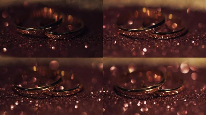 结婚戒指躺在闪亮的表面上，闪耀着光亮的特写微距