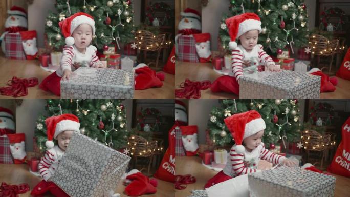 女婴在家里的圣诞树前打开礼品盒